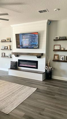 a flat screen tv mounted above a fireplace in a living room