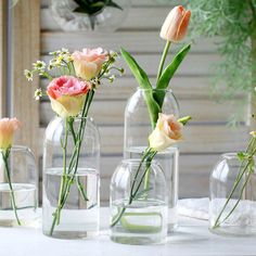 several vases with flowers in them sitting on a table