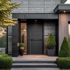 an entrance to a modern home with black doors