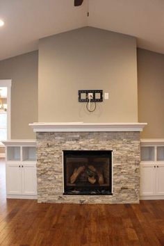 an empty living room with wood floors and a fireplace