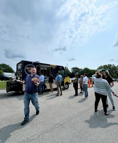 a group of people standing in front of a food truck