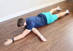 a man laying on the floor with his hands behind his back and feet in the air