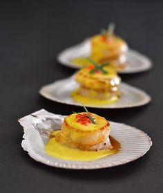 three white plates topped with food on top of a black table next to each other