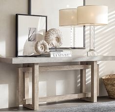 a console table with two seashells on top and a lamp next to it