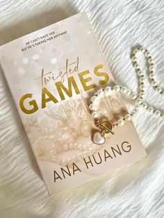 a book is laying on a bed next to a rosary and necklace with the title just married games written in gold