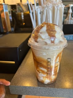 there is a drink with ice cream and caramel in it sitting on the counter