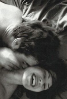 black and white photograph of two people laying on top of each other