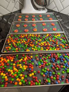 three trays filled with candy sitting on top of a counter