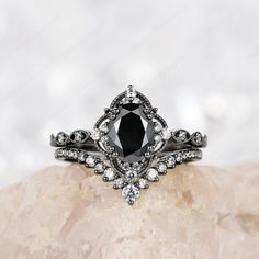 a black diamond ring sitting on top of a rock