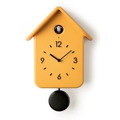 a yellow clock with black hands and numbers on the face is hanging from a wall