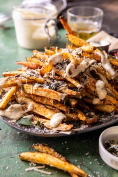 a plate filled with french fries covered in sauce and parmesan cheese on top