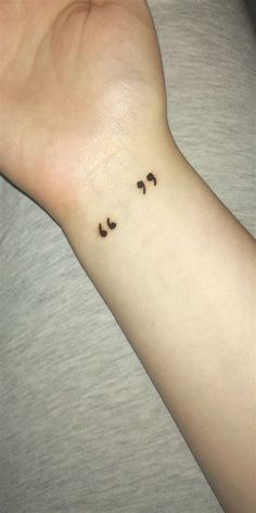 a person's wrist with small black birds on it