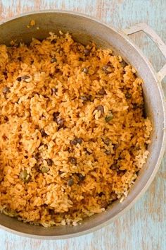 a pot filled with rice and raisins on top of a blue tablecloth