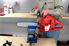 a man holding a chainsaw on top of a wooden table