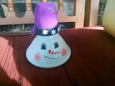 a snowman hat sitting on top of a wooden bench