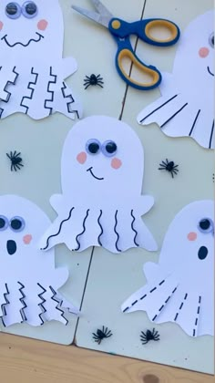 paper cut out of the shape of ghostes with scissors