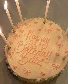 a birthday cake with white frosting and lit candles