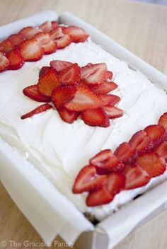 a close up of a cake with strawberries on it and the words clean eating canada day cake