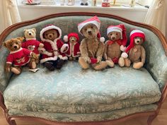 five teddy bears in santa hats sitting on a couch