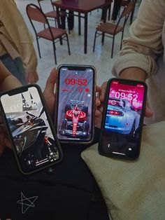 three people holding up their cell phones in front of them, with the same screen