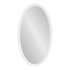 a white round mirror sitting on top of a wall