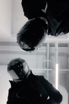 two people wearing helmets in a room