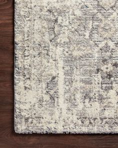 an area rug on top of a wooden floor with white and gray colors in the middle