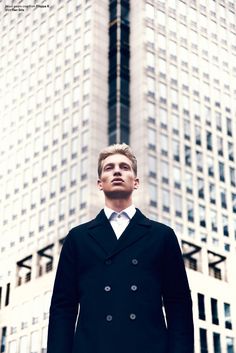 a man standing in front of a tall building with the words mmscene executive