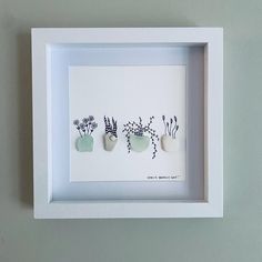 three small vases with plants in them on a white background framed paper art piece