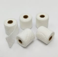 four rolls of toilet paper on a white surface