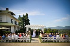 a bride and groom standing at the end of their wedding ceremony in front of an outdoor venue