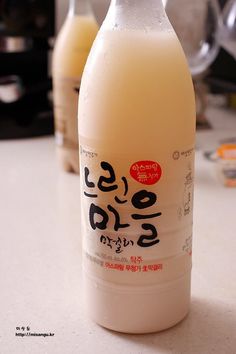 two bottles of milk sitting on top of a counter