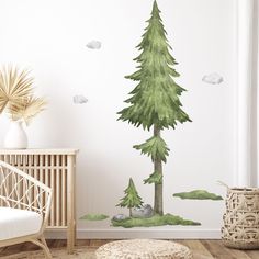 a room with a tree and clouds painted on the wall next to a crib