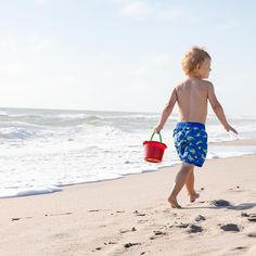 A boy is walking down the beach with a red bucket Snow Play, Free Coloring Sheets, Green Toys, Interactive Play, Sand And Water, Water Toys