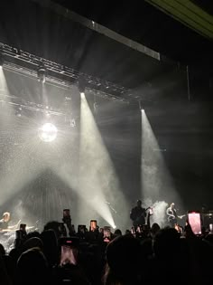 a group of people standing on top of a stage with lights coming from behind them