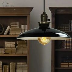 a black and white light hanging from a ceiling fixture in a room with bookshelves