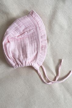 A new sweety baby pink lightweight hat from us,  the baby bonnet. This lightweight hat with ties, sits loosely on your little ones head, offering protection from wind and sun. It is so nice as baby gift. This hat is made out of blush double cotton gauze, washed and dried for a soft, comfortable fit. A ruffled brim adds a touch of softness for your little girl.   All materials used are Oeko-Tex Certified to protect children's health. It will be sewn immediately after the order has been placed and sent to you no later than 5 working days.   For everyday or special occasions. Sizes are : 0-3 months                    3-6 months                    6-9 months                    9-12 months                    12-18 months                    18-24 months Color : Pink Made and designed by Siminie Cute Pink Cotton Bonnet, Pink Cotton Hat Gift, Cute Adjustable Bonnet For Summer, Pink Cotton Bonnet For Spring, Cute Pink Bonnet With Curved Brim, Adjustable Pink Bonnet As Gift, Adjustable Pink Hat With Ruffles, Spring Adjustable Bonnet, Cute Adjustable Bonnet As Gift