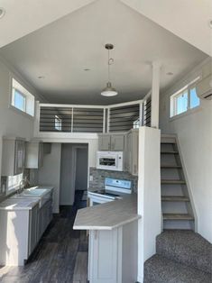 an empty kitchen with stairs leading up to the loft