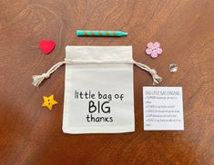 a little bag of big thanks on a table next to some paper hearts and pins