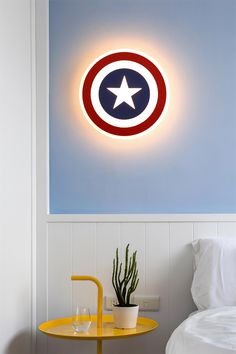 the captain's shield light is mounted on the wall above a small table with a potted cactus