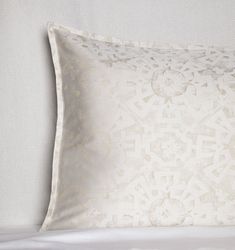 a white pillow on top of a bed