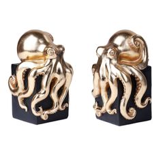 an image of two golden octopus sculptures on black bases with white background and gold accents