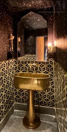 a bathroom with gold fixtures and black walls