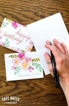 someone is writing happy birthday cards on the table