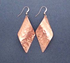 Diamond shaped copper dangles are hammered for texture and polished for shine.  Swingy curvy design reflects light with every little motion.  Ear hooks are handcrafted in 14k rose gold filled wire.  Lightweight for all day comfort.Earring Dimensions:Width - 1 inch (2.5cm)Length - 2 3/4 inches (7cm)More copper jewelry:https://www.etsy.com/shop/SeventhWillow?ref=hdr_shop_menu&search_query=copperWelcome to Seventh Willow:seventhwillow.etsy.comE410 x 19th Anniversary Gifts, Hammered Copper Earrings, Bronze Anniversary Gifts, Copper Anniversary Gifts, Copper Jewellery, 7th Anniversary Gifts, Cuff Bracelets Handmade, Jewelry Education, Anniversary Gift For Wife