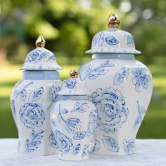 three blue and white vases sitting on top of a table