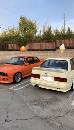 two cars parked next to each other in a parking lot near an ice cream cone