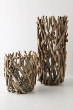 two vases made out of branches sitting on a table top next to each other