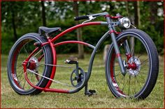 a red and silver bicycle parked in the grass