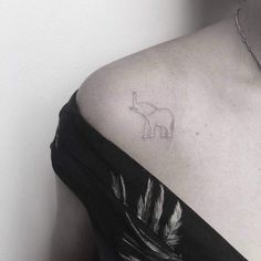 a small elephant tattoo on the back of a woman's upper arm and shoulder